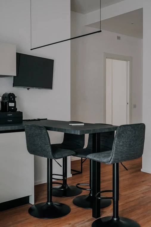 Casa Lollo – Trastevere, Roma: il tavolo da pranzo con gli sgabelli e la televisione